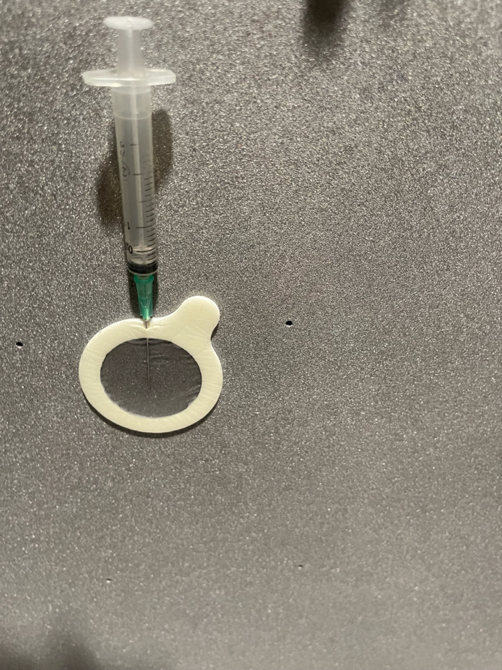 Bresle test needle inserted into a test patch on a coated surface